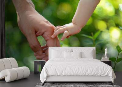 Medium close-up of a childâs hand gripping an adultâs finger tightly, representing trust and hope for the future. Wall mural